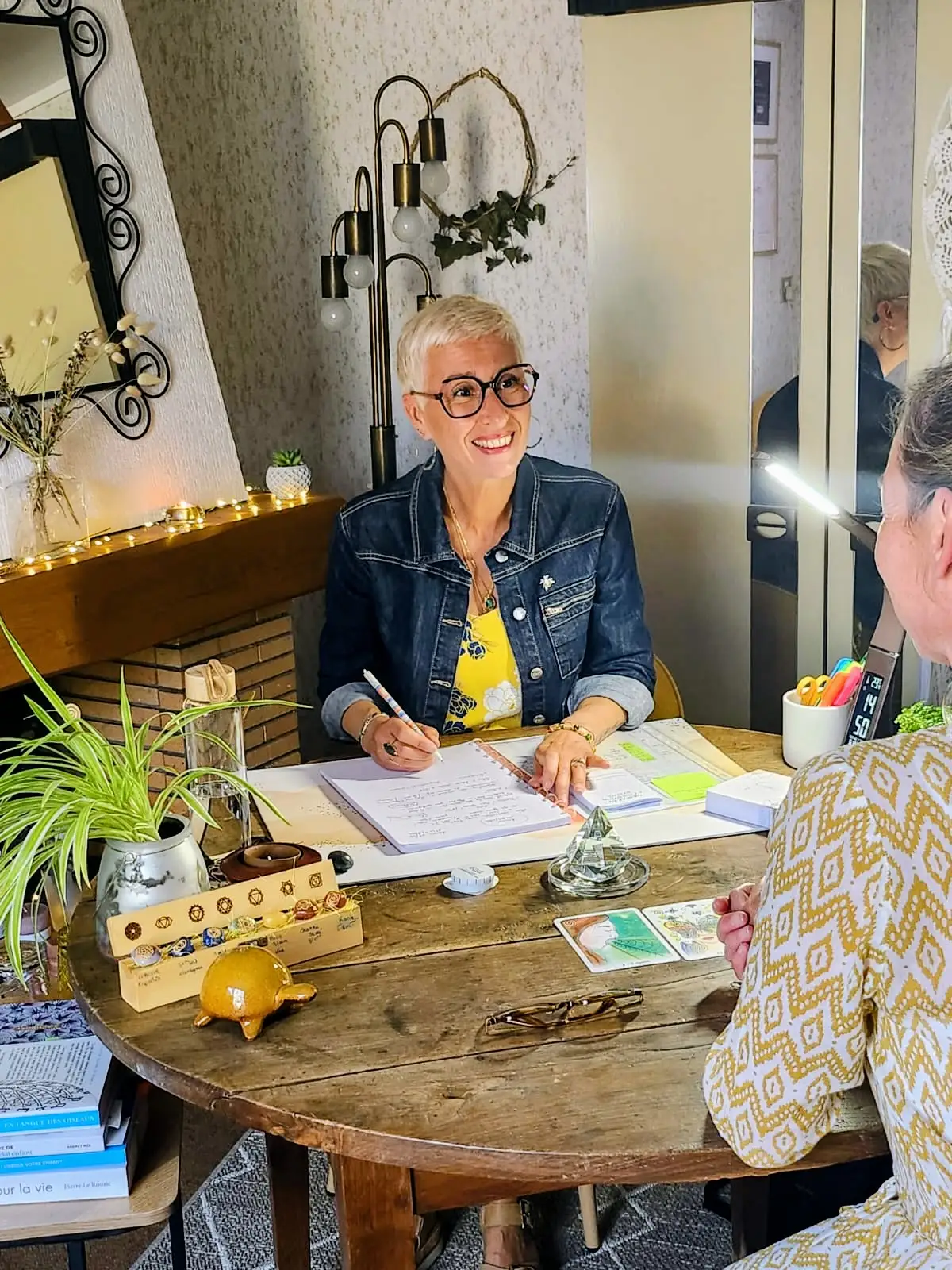 Christine Boury assise à son bureau avec une patiente en train de prendre des notes pendant une séance